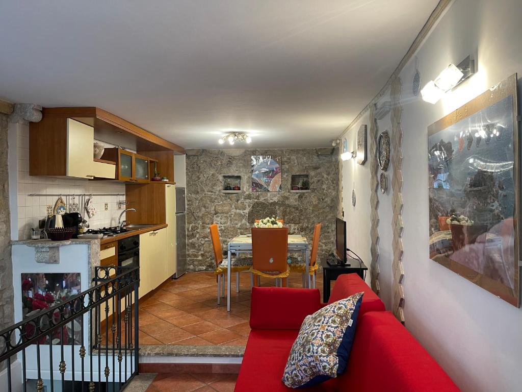 a living room with a red couch and a table at Majolica Taormina Apartment in Taormina