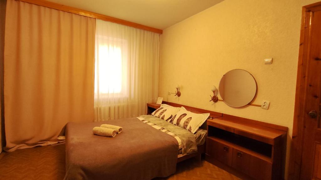 Vasylia Stusa 3 CityRooms في بيلا تسيركفا: غرفة نوم بسرير ومرآة ونافذة