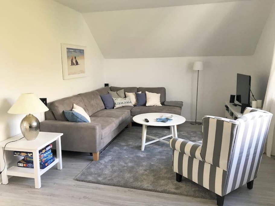 uma sala de estar com um sofá, uma mesa e uma cadeira em Ferienwohnung Sonnendeck em Eckernförde