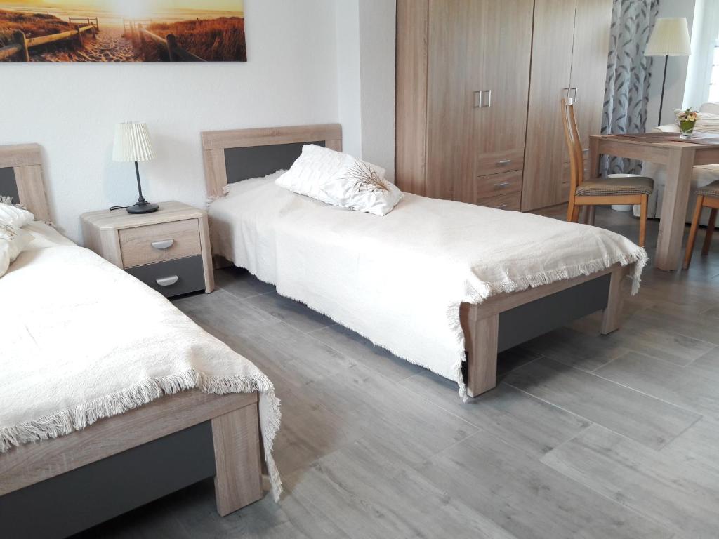 a bedroom with two beds and a table with a chair at Ferienwohnung "Jasmund" in Sagard auf Rügen in Sagard