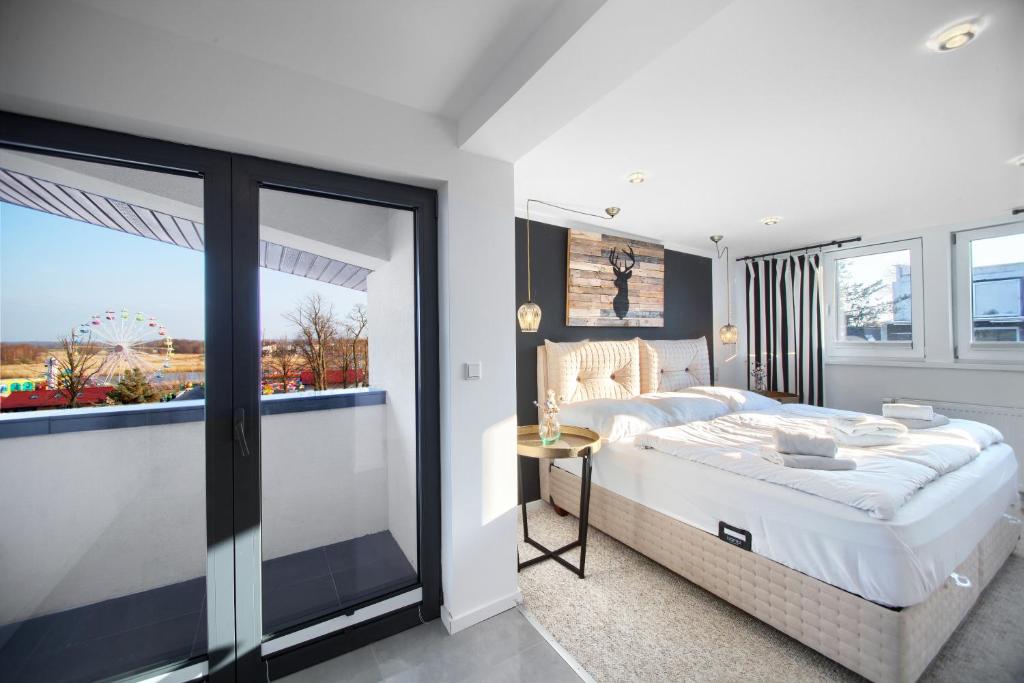 a bedroom with a large bed and a large window at AP Baltic Mielno in Mielno