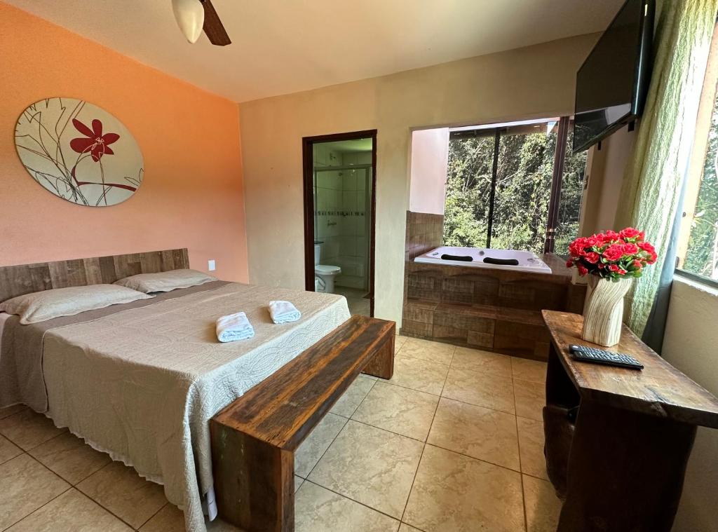 a bedroom with a bed and a bathroom with a tub at Macaco Prosa in Macacos