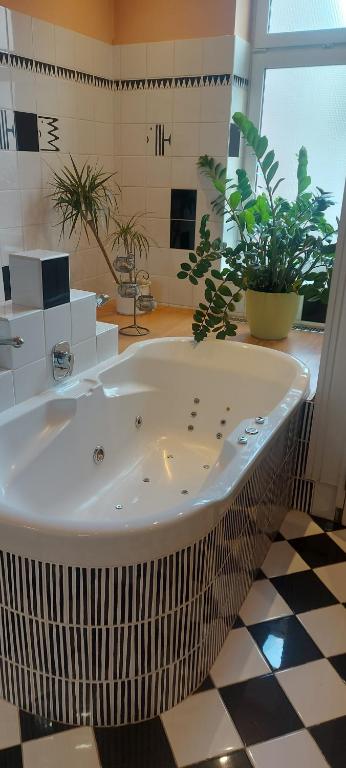 eine große weiße Badewanne in einem Zimmer mit Pflanzen in der Unterkunft Apartment Belvedere in Ostrava