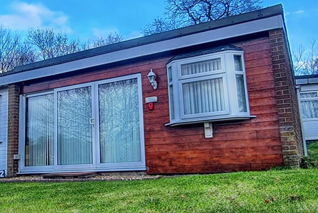a red brick house with a large window at Ranger - Snowdon Cabins holiday let Caernarfon in Caeathro