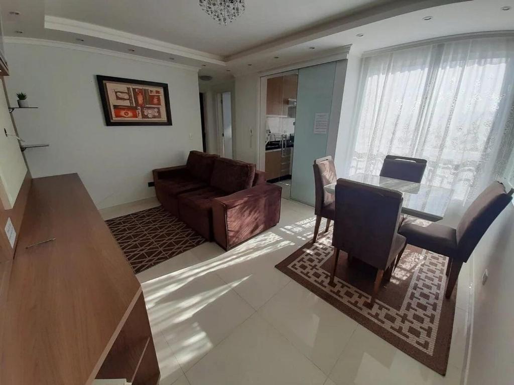ein Wohnzimmer mit einem Sofa und einem Tisch in der Unterkunft Apartamento inteiro com garagem coberta Treviso in União da Vitória
