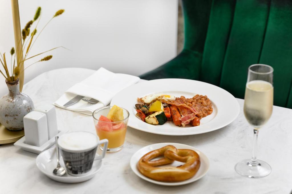 a table with two plates of food and a drink at Nemzeti Hotel Budapest - MGallery Collection in Budapest