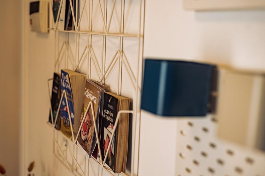 a group of books hanging on a wall at Breathe In in Zambujeira do Mar