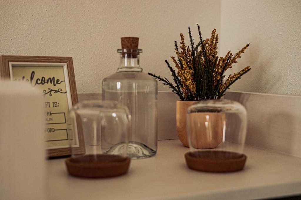 a table with two glass jars and a bottle on it at Breathe In in Zambujeira do Mar