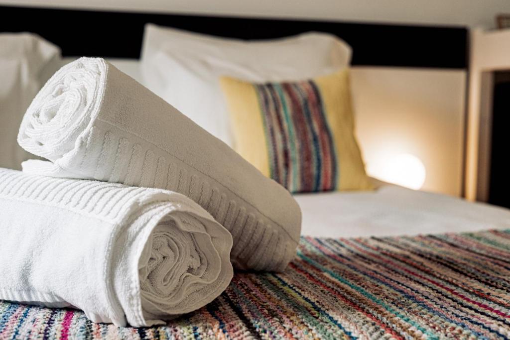 a pile of towels sitting on top of a bed at Breathe In in Zambujeira do Mar