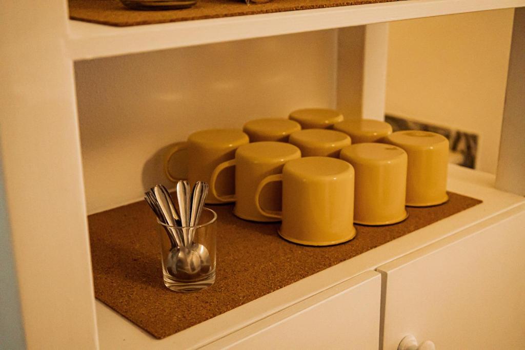 a kitchen cabinet with yellow cups on a counter at Breathe In in Zambujeira do Mar