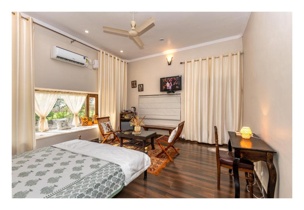 a bedroom with a bed and a desk and a table at Tranquility homestay in Shivpurī