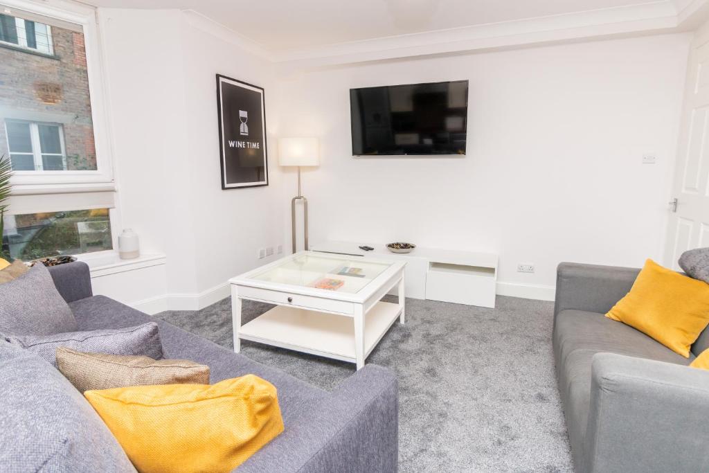Una sala de estar con dos sofás y un televisor. en D'City Apartment, up to 5 guests, en Dundee