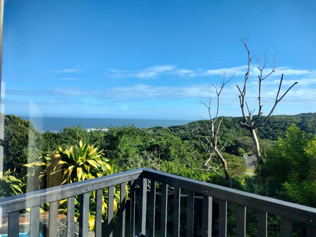 a balcony with a view of the ocean at Cove Rock Stay in East London