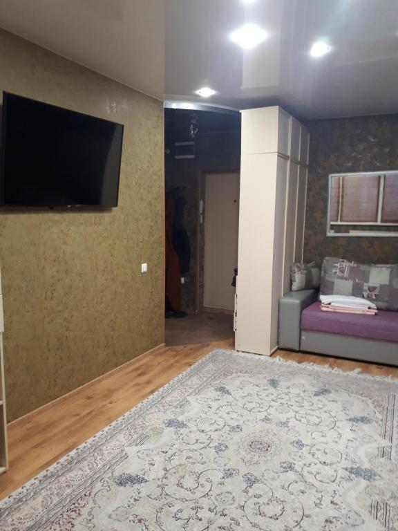 sala de estar con TV de pantalla plana en la pared en Апартаменты на набережной в Актау, en Aktau