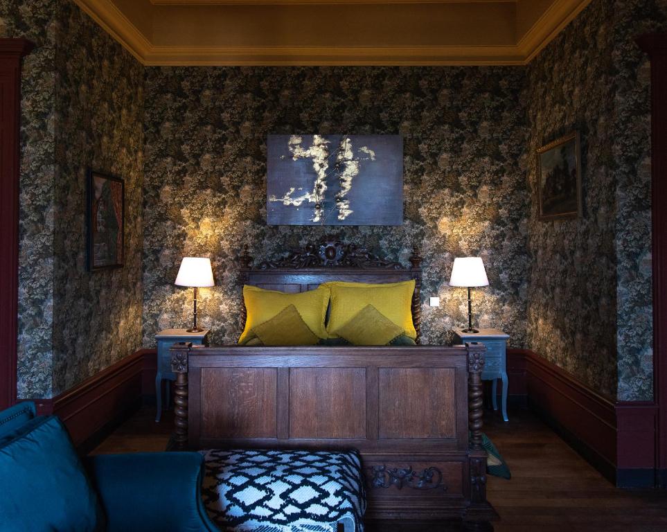 a bedroom with a bed and two tables with lamps at Château de Pramenoux in Lamure-sur-Azergues