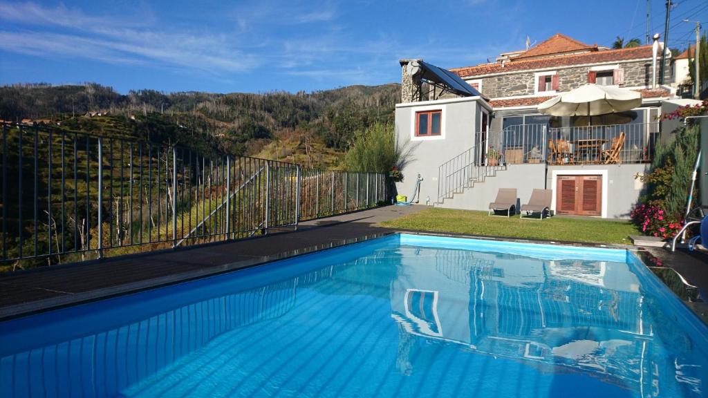 uma piscina em frente a uma casa em Refúgio da serra em Arco da Calheta