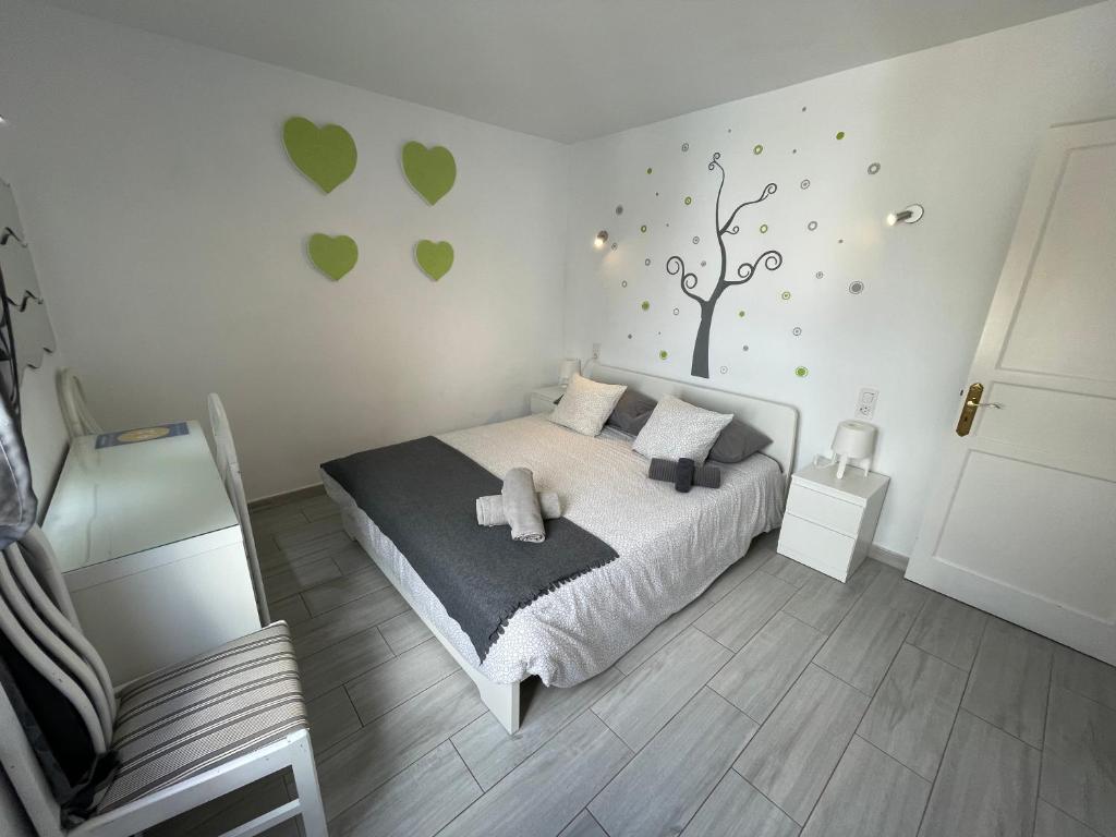 a bedroom with a bed and a tree on the wall at New Pistachio Apartment in Costa Teguise