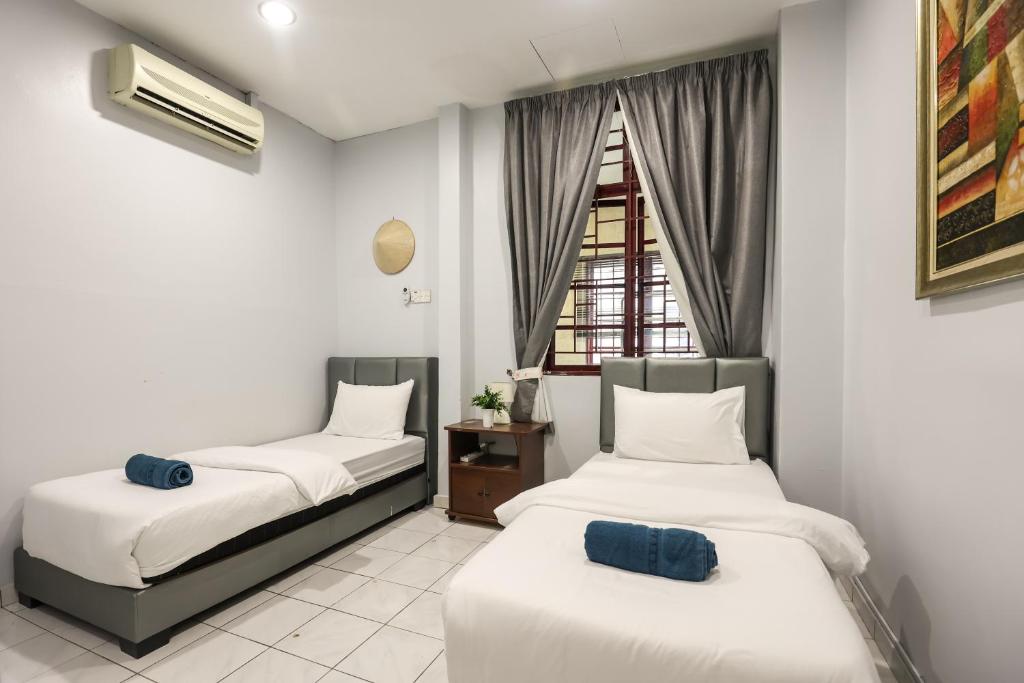 twee bedden in een kamer met een raam bij Kota Damansara ICozy Cove Homestay 10 Pax in Petaling Jaya