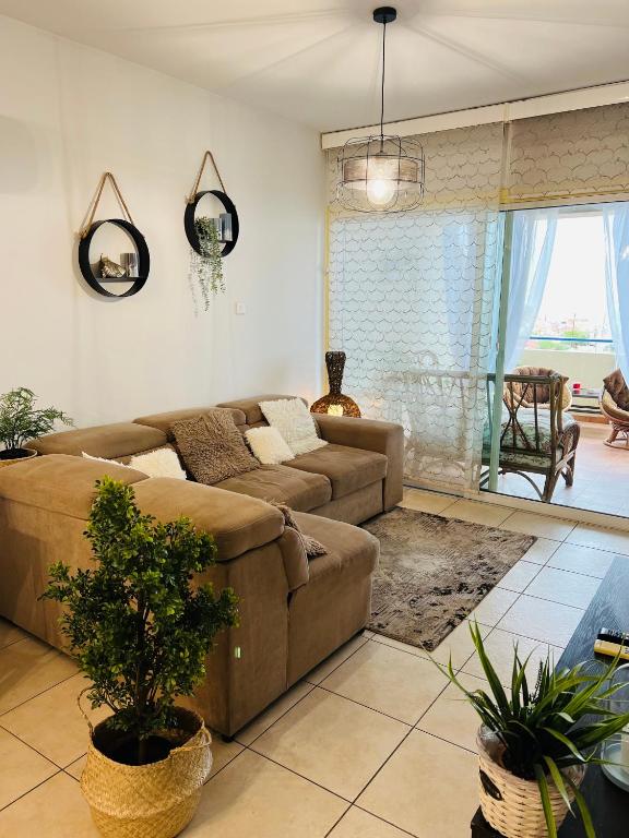 a living room with a couch and a table at Carisa Holiday rooms in Larnaca