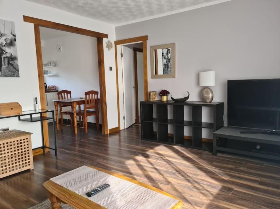 un soggiorno con una grande TV a schermo piatto di Charming spacious 2 bed apartment in quiet area a Exhall