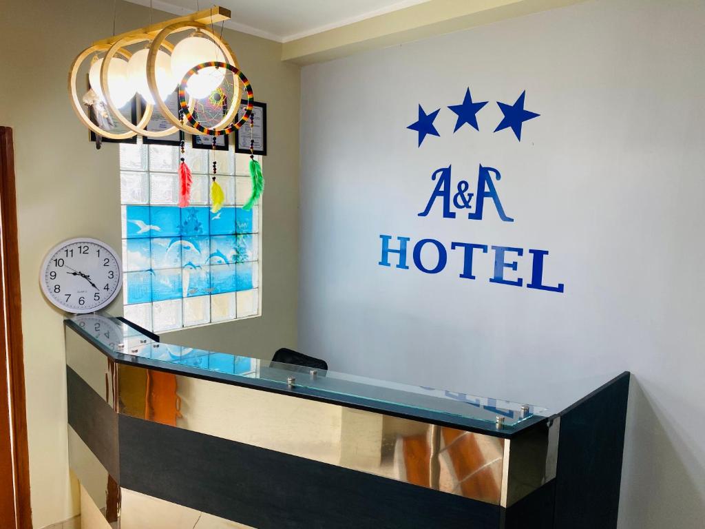a hotel reception desk with a clock and aaa hotel sign at A&A HOTEL in Iquitos