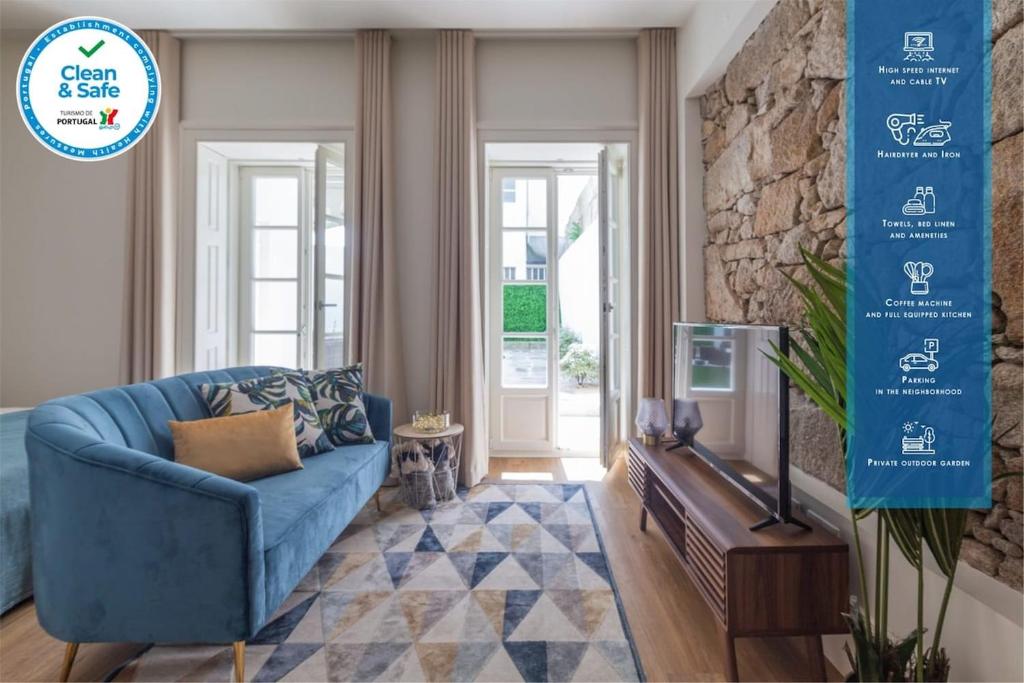 un salon avec un canapé bleu et une télévision dans l'établissement Charm Luxury House, à Porto