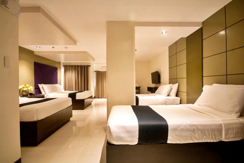 Habitación de hotel con 2 camas y sofá en ECL Resort Hotel Boracay en Boracay