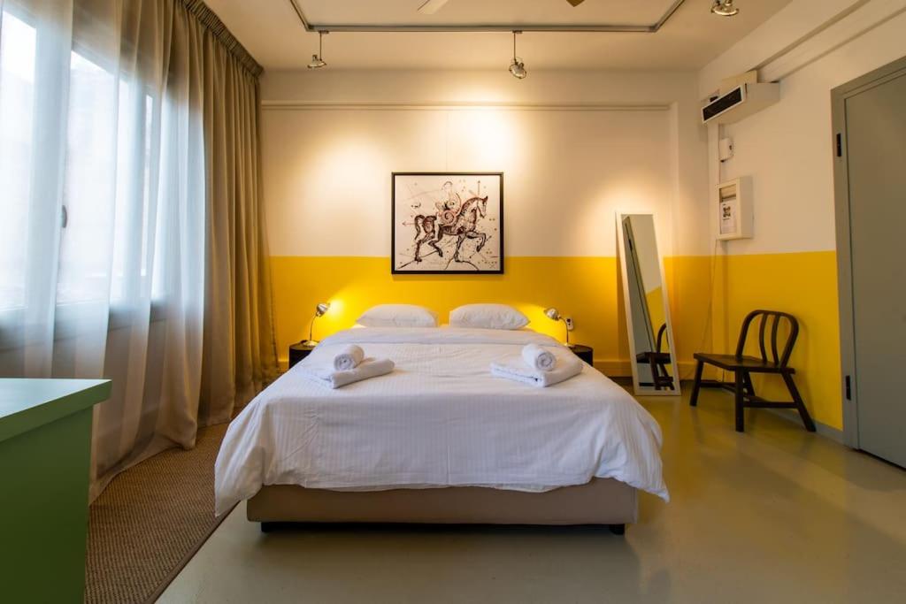 a bedroom with a large bed with towels on it at Artistic Spacious Studio Apartment next to metro Monastiraki in Athens