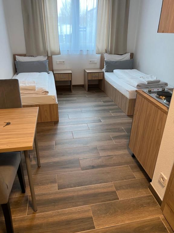 Habitación pequeña con 2 camas y mesa. en Boardinghouse MDS, en Aschheim