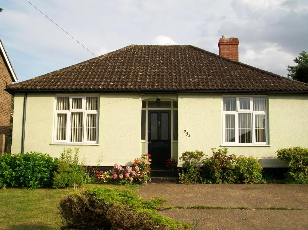 een wit huis met een bruin dak bij Beech Tree in Bury Saint Edmunds