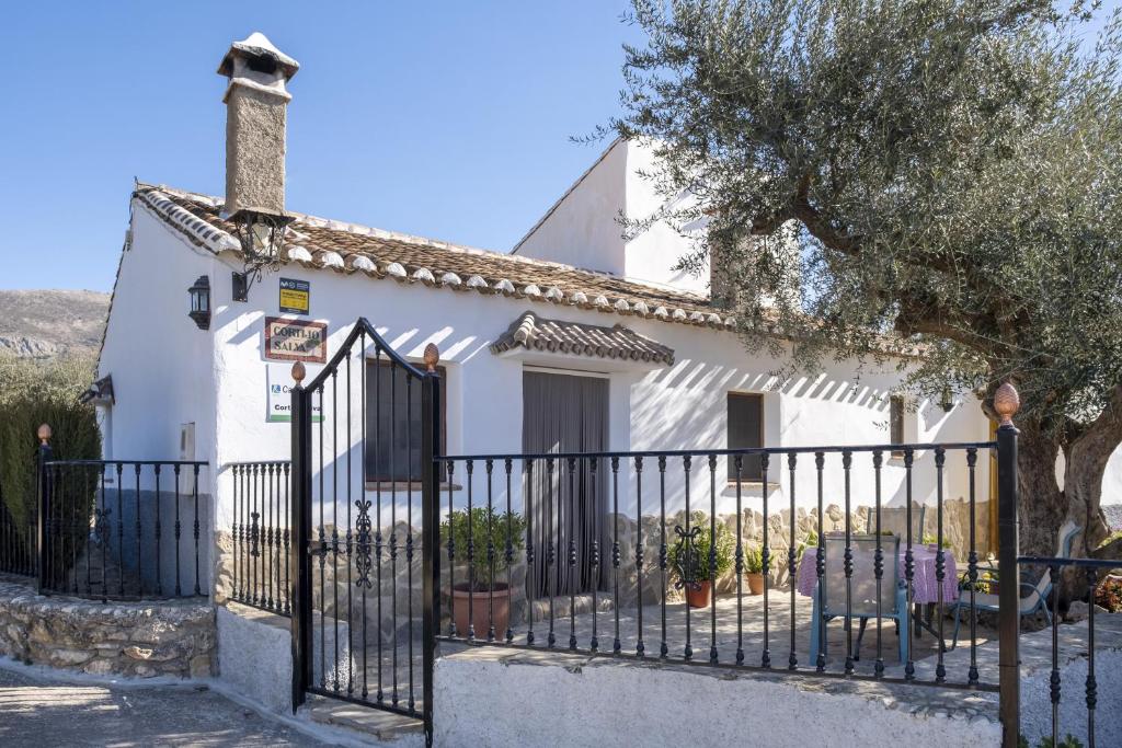 uma casa branca com uma cerca preta em Cortijo Salva em Periana
