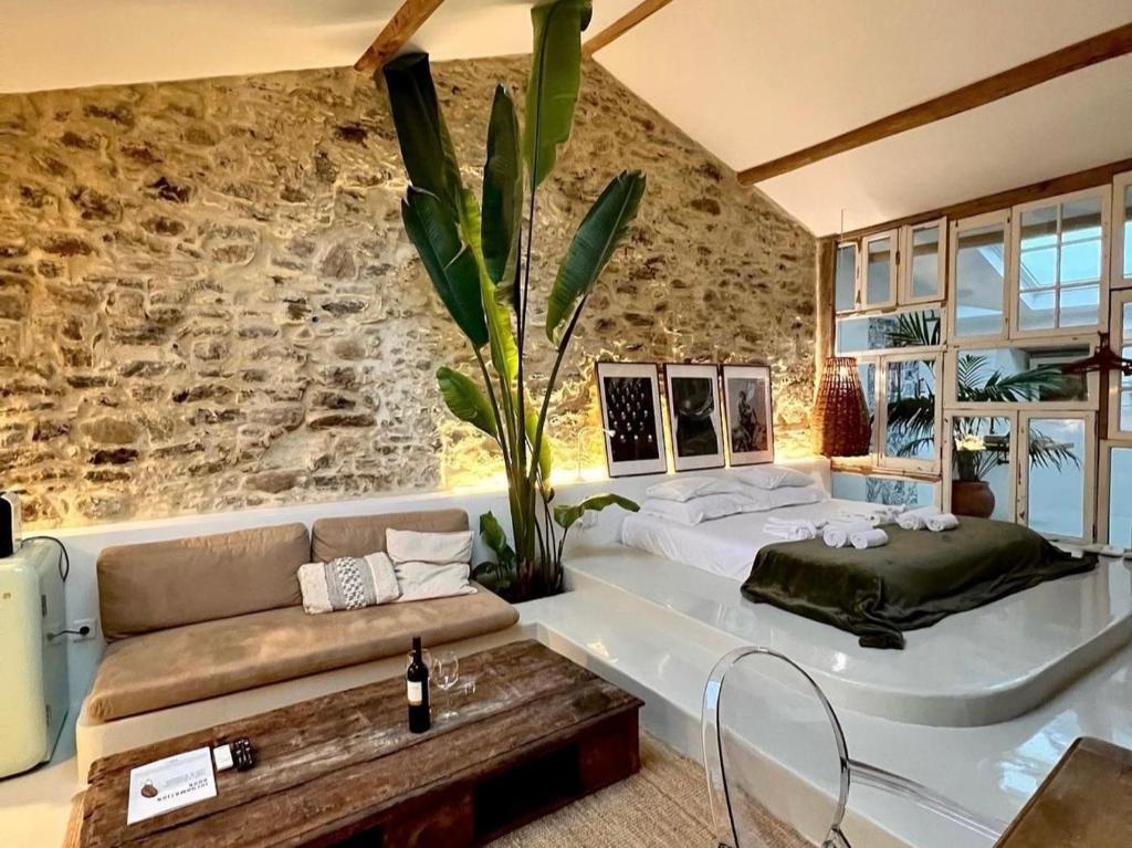 een slaapkamer met een groot bed en een stenen muur bij Suites D´aldeia - Suite 16 in Mafra
