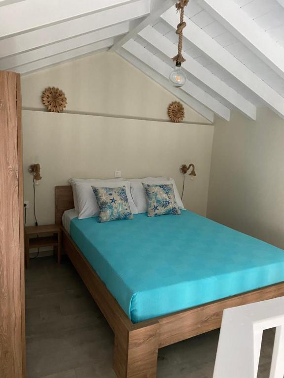 a bedroom with a large bed with blue sheets at Aleminas Rooms in Symi