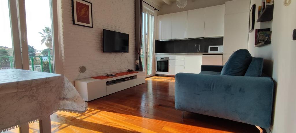 a living room with a blue couch and a kitchen at House Orizzonte - Casa Bianca in Genoa