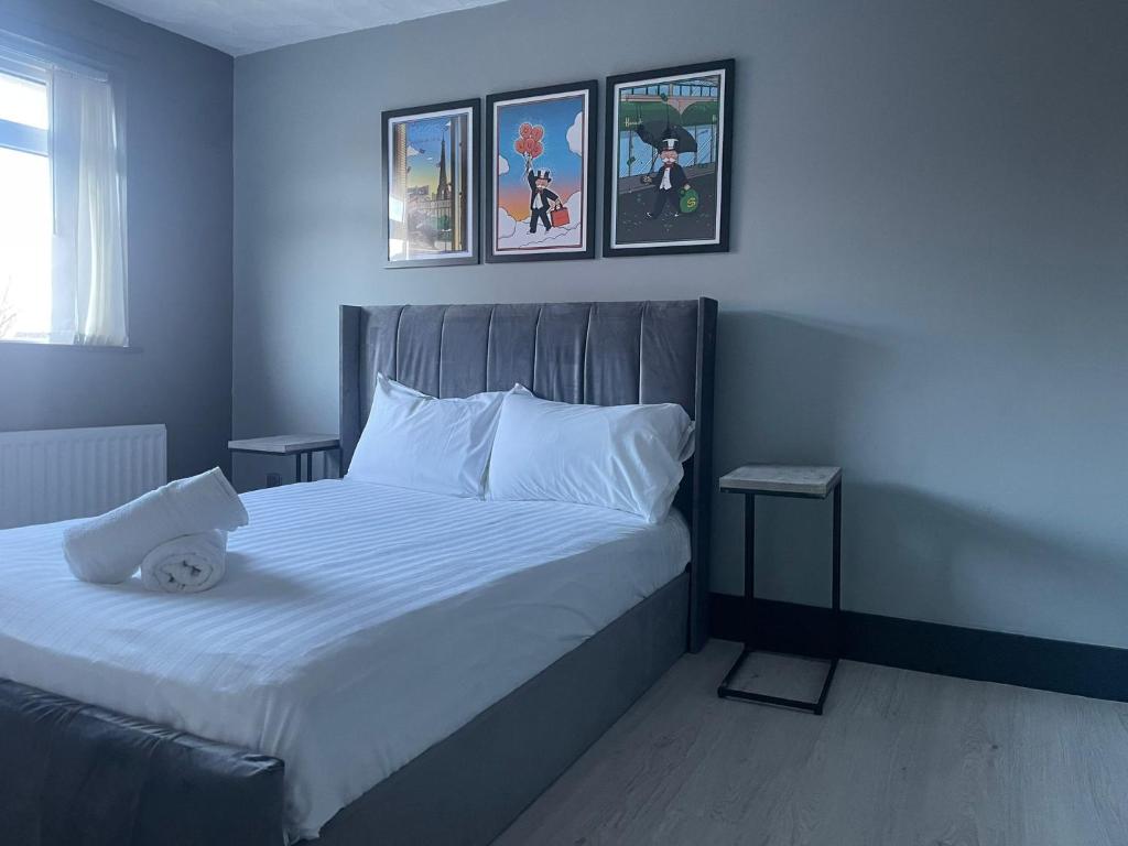 ein Schlafzimmer mit einem großen weißen Bett mit drei Bildern an der Wand in der Unterkunft NEW 3-Bedroom Newcastle House in Lemington