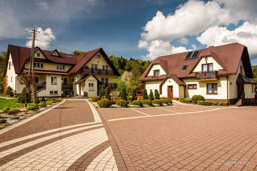 a large house with a brick driveway in front of it at Kozinówka in Zawoja