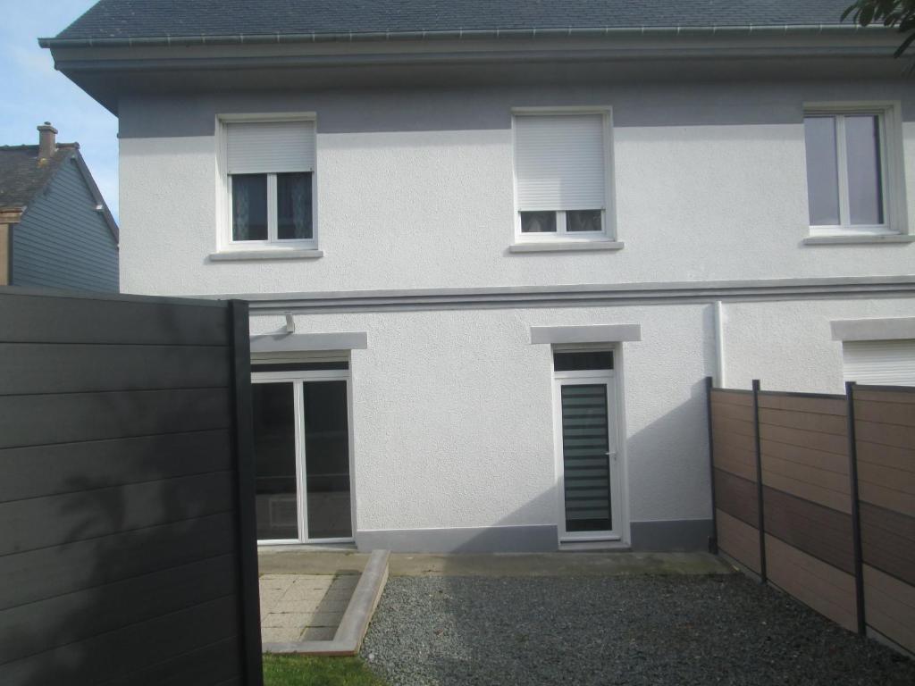 een wit huis met een hek ervoor bij TY PLAGE in Saint-Cast-le-Guildo