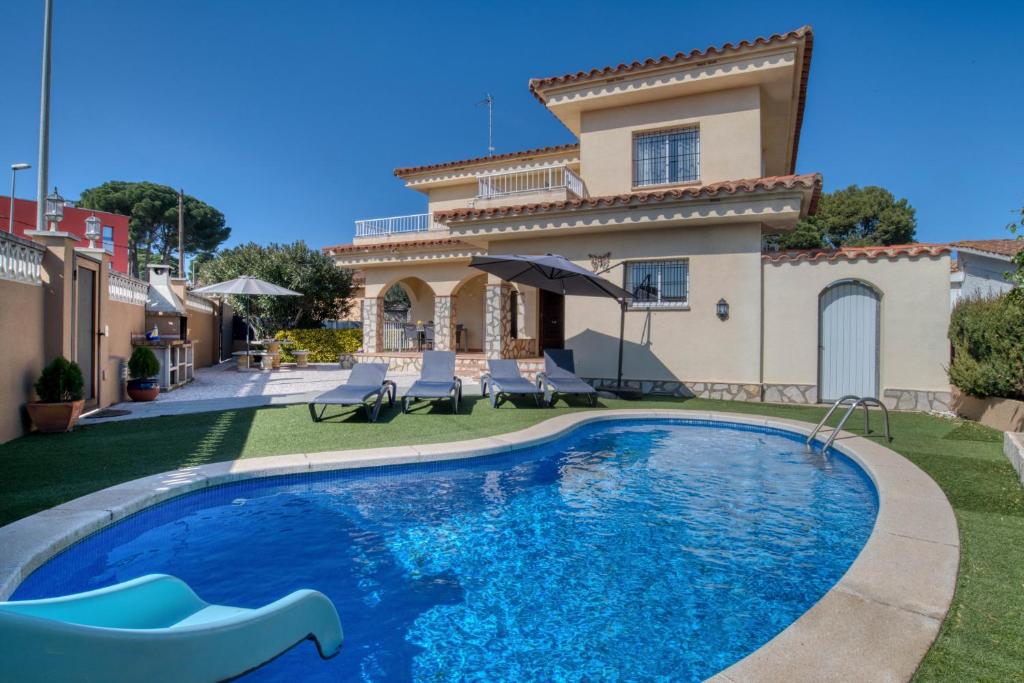 a villa with a swimming pool in front of a house at Vela, casa con piscina privada a pocos metros de la playa in L'Escala