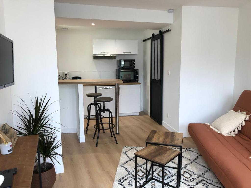 sala de estar con sofá y cocina en TERRA Studio cosy et calme proche du centre avec parking TV Netflix et Wifi, en La Rochelle