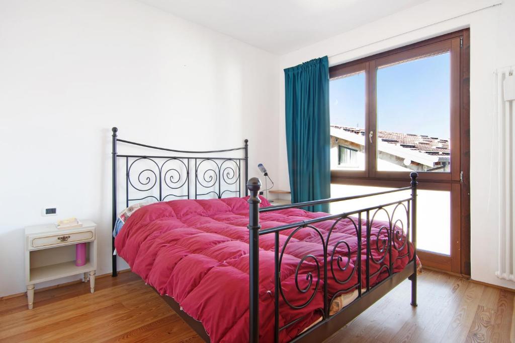 1 dormitorio con 1 cama con edredón rojo y ventana en Casa Leonardo, en Dorio