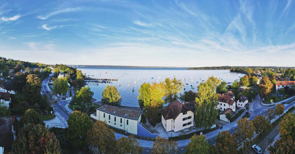 eine Luftansicht auf einen See mit Häusern und Bäumen in der Unterkunft Seespitz Gästehaus in Herrsching am Ammersee