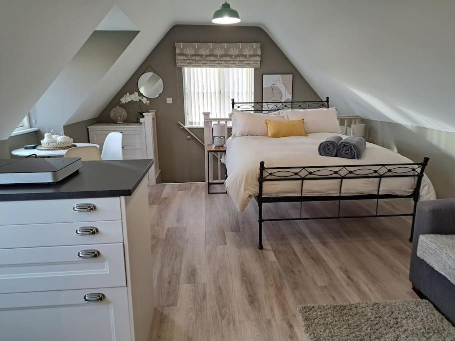 a bedroom with a bed and a desk in a attic at Suffolk View Apartment in Tuddenham