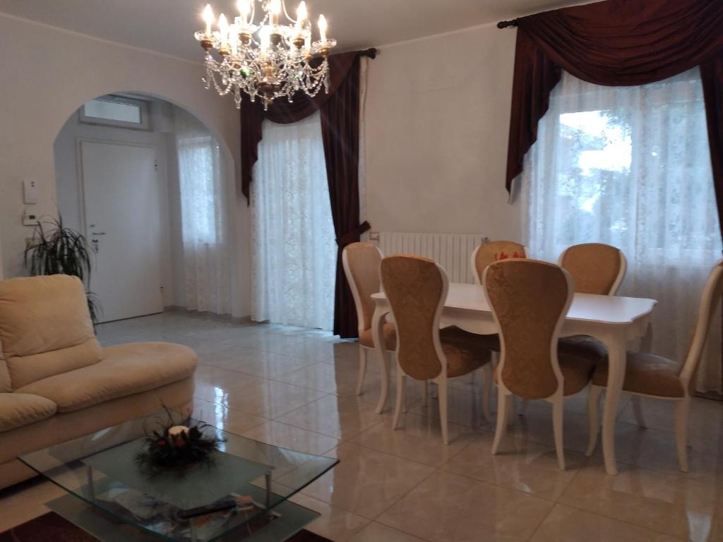 a living room with a table and chairs and a chandelier at Casa di Tina in Castellana Grotte