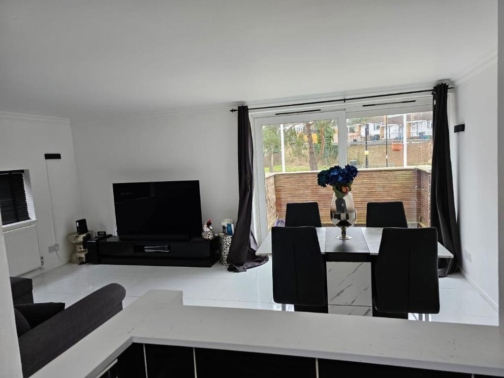 a living room with a table with a vase of flowers on it at Homely Cozy 1 bedroom Apartment in Addington