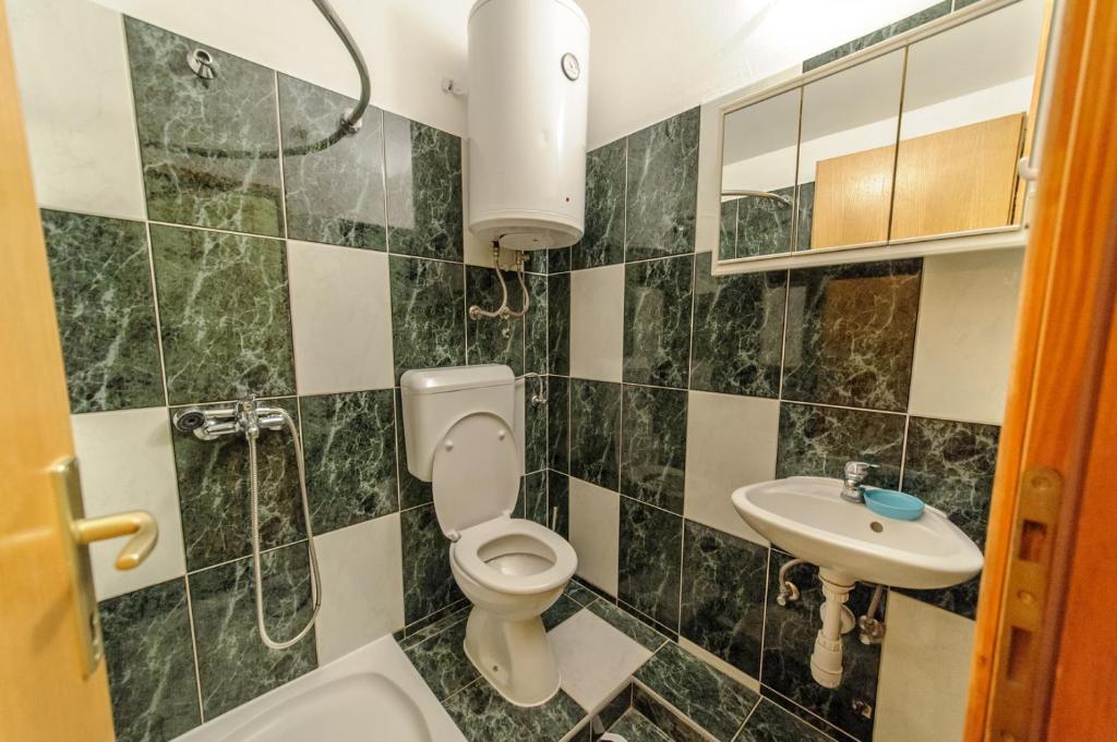 a bathroom with a toilet and a sink at Apartments & rooms Lucie in Posedarje