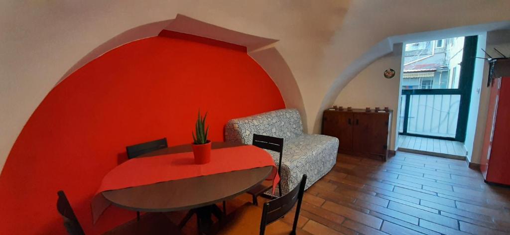 une salle à manger avec une table et un mur rouge dans l'établissement Partenope Magica, à Naples