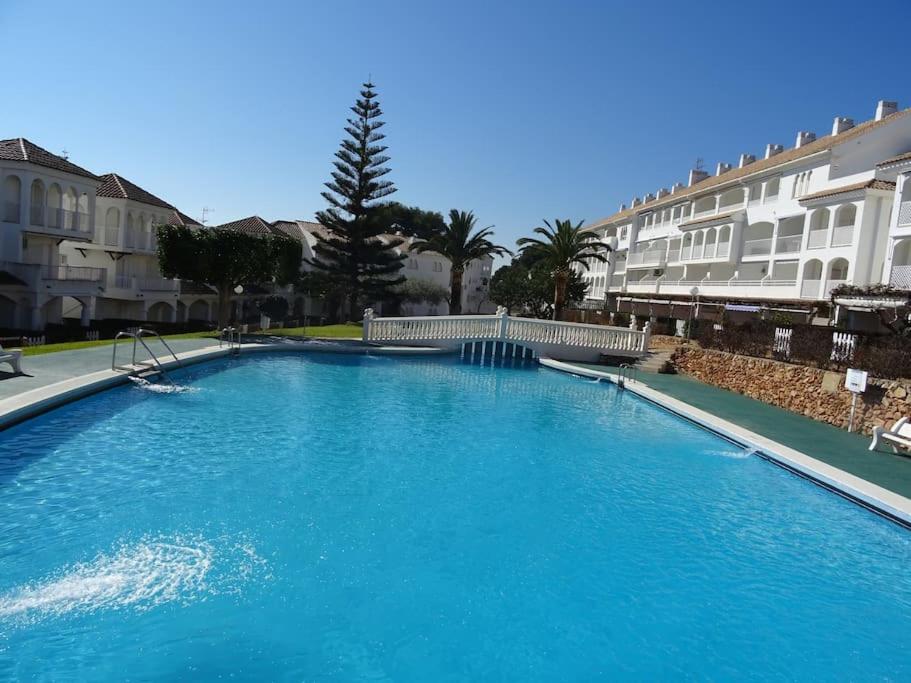 a large blue swimming pool in front of some buildings at AL203 céntrico, piscina y garaje AL203 in Alcossebre
