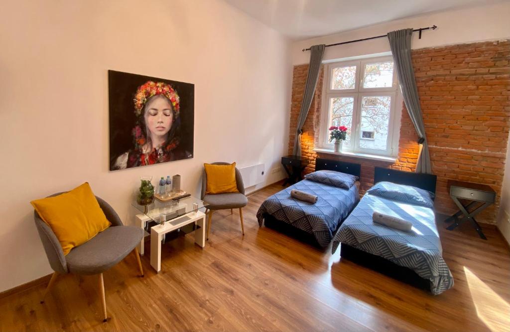 a living room with a bed and a painting of a woman at Topolove Rooms & Apartments in Kraków