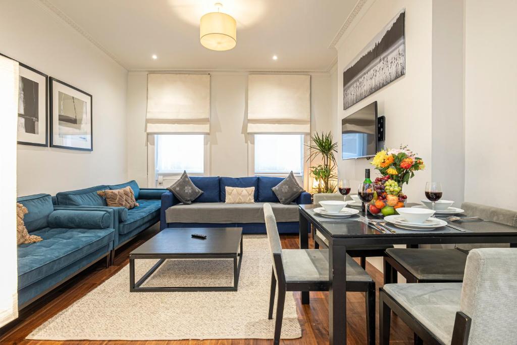 Goodge Apartments في لندن: غرفة معيشة مع أريكة زرقاء وطاولة