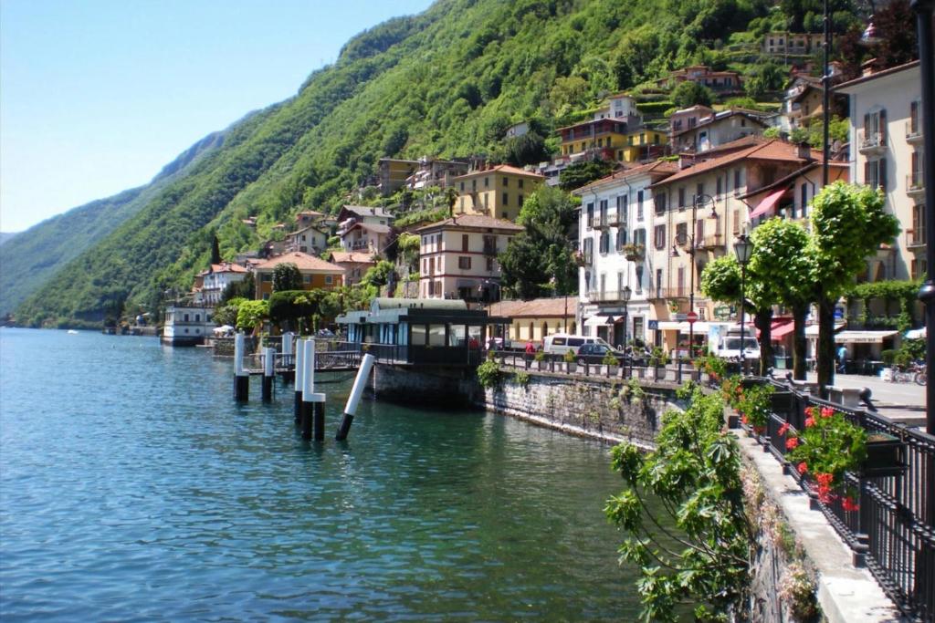 a view of a river with houses on a hill at Casa Hygge Argegno – Lake Como in Argegno